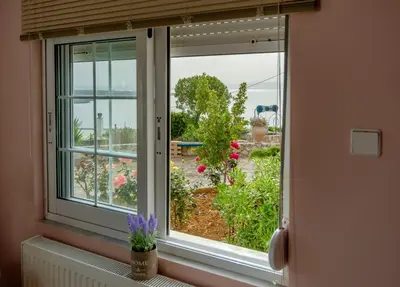 a window with a view of a garden at Seashore Apartments in Chorafakia