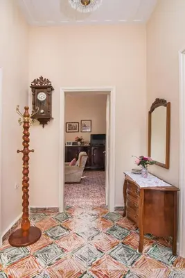 a room with a clock and a table and a mirror at Nina's House in Kamisianá