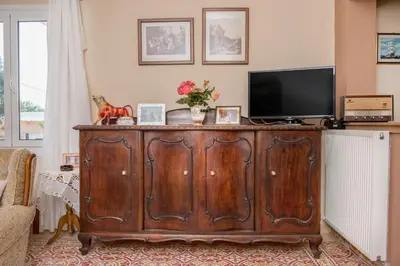a living room with a wooden cabinet with a tv on it at Nina's House in Kamisianá