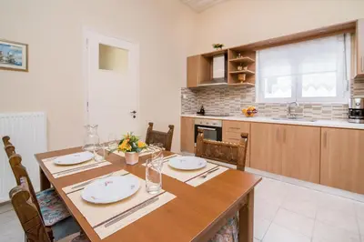 a kitchen with a wooden table and a dining room at Nina's House in Kamisianá