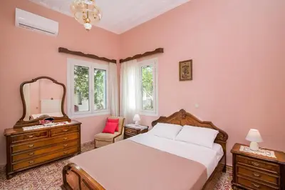 a bedroom with a bed and a mirror and a chair at Nina's House in Kamisianá