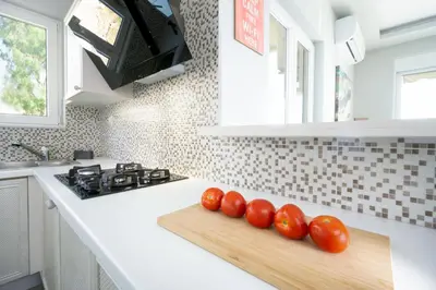 three tomatoes on a cutting board on a kitchen counter at Rooftop Jacuzzi Apartment in Chania Town