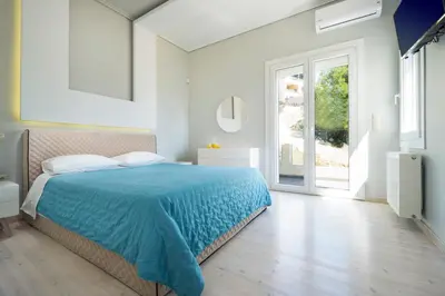 a bedroom with a blue bed and a window at Rooftop Jacuzzi Apartment in Chania Town