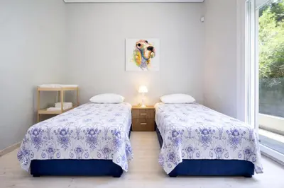 two beds in a room with a window at Rooftop Jacuzzi Apartment in Chania Town
