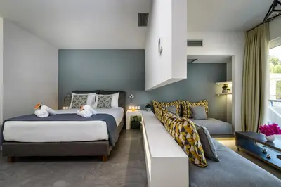 a bedroom with two beds and a couch at Solar Apartments by Amara Living in Agia Marina Nea Kydonias