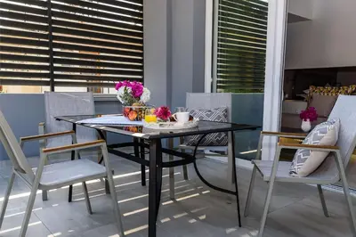 a black dining table and chairs on a balcony at Solar Apartments by Amara Living in Agia Marina Nea Kydonias