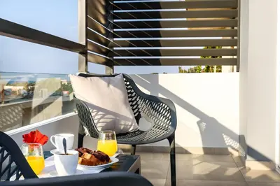 a table with a plate of food and two glasses of orange juice at Solar Apartments by Amara Living in Agia Marina Nea Kydonias