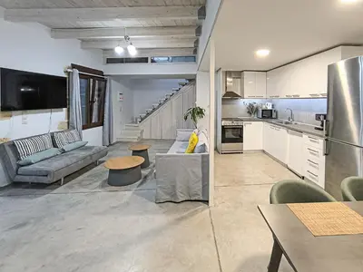 a large living room with a couch and a kitchen at Charming Old Tannery House with Spacious Veranda and Stunning Sea View! in Chania Town
