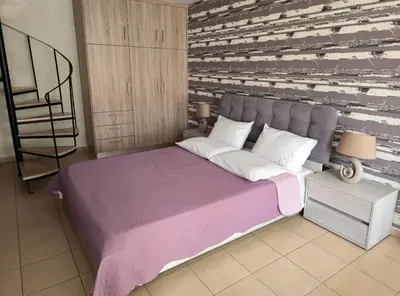 a bedroom with a large bed and a wooden wall at Emily's House in Kissamos