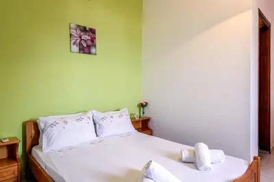a bedroom with a bed with white sheets and pillows at Antonis Studio in Sfinárion