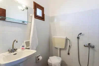 a bathroom with a toilet and a sink and a shower at Antonis Studio in Sfinárion