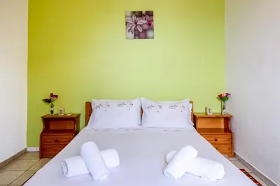a bedroom with a white bed with two white pillows at Antonis Studio in Sfinárion