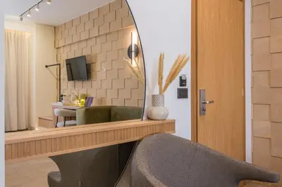 a living room with a mirror and a chair at Agave Suites in Chania Town