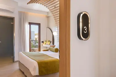a bedroom with a bed and a door with a window at Agave Suites in Chania Town