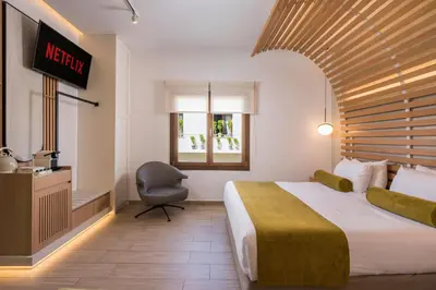 a hotel room with a bed and a television at Agave Suites in Chania Town