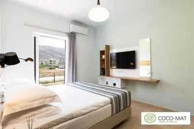 a bedroom with a bed and a tv and a window at Ethereal Apartments Chania in Souda