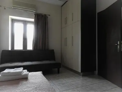 a living room with a black couch and a window at Chrissi's house with garden and sea view Zerviana in Kissamos
