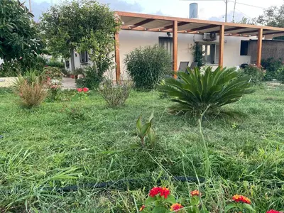 a house in a yard with grass and flowers at Chrissi's house with garden and sea view Zerviana in Kissamos