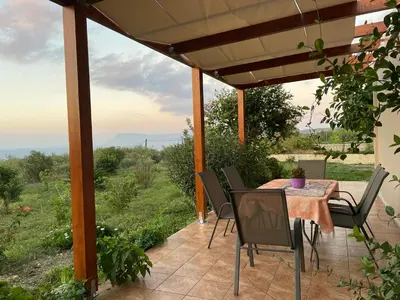 a table and chairs on a patio with a view at Chrissi's house with garden and sea view Zerviana in Kissamos