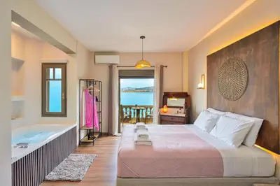 a bedroom with a large bed and a bath tub at East Seafront Suite in Chania Town
