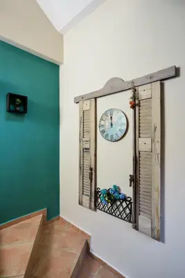 a clock on a wall in a room with a staircase at East Seafront Suite in Chania Town