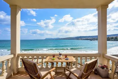 a porch with a table and chairs and the ocean at East Seafront Suite in Chania Town