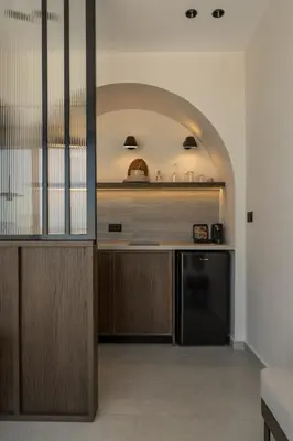 a kitchen with wooden cabinets and a black dishwasher at Thelèsi Apartments, 100m from the beach in Stalos