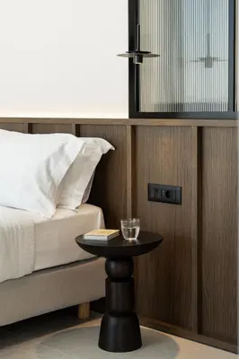 a bedroom with a bed and a table with a book at Thelèsi Apartments, 100m from the beach in Stalos