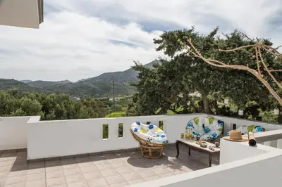a view from the balcony of a house with a table and chairs at Kyparissos Apartment I in Kissamos