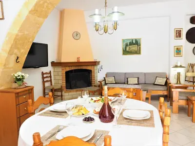 a living room with a table and a fireplace at Traditional Cretan Villa in Rodhopós