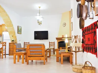 a living room with wooden furniture and a tv at Traditional Cretan Villa in Rodhopós