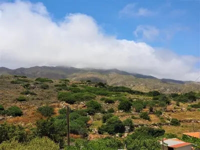 a view of a mountain with clouds in the sky at Traditional Cretan Villa in Rodhopós