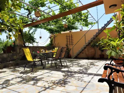 a patio with a table and chairs under a pergola at Traditional Cretan Villa in Rodhopós