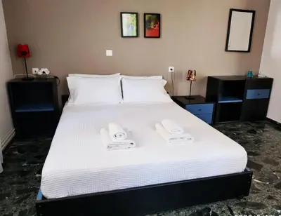 a bedroom with a white bed with two towels on it at Zacharoula's Home in Chania Town