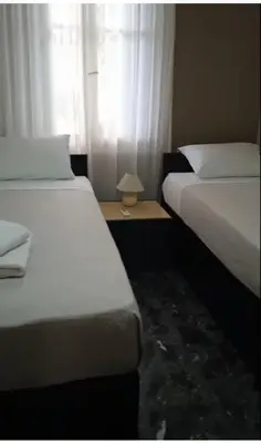 two beds in a hotel room with a window at Zacharoula's Home in Chania Town