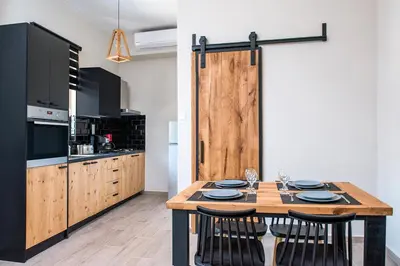 a kitchen with a wooden table with chairs and a wooden door at Elegant Apartment in Chania Town