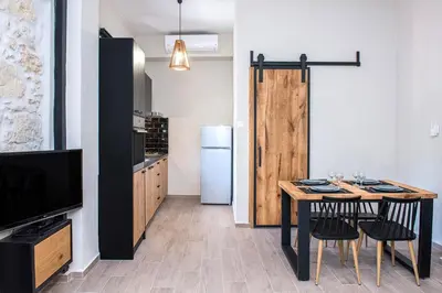 a small kitchen with a table and a refrigerator at Elegant Apartment in Chania Town