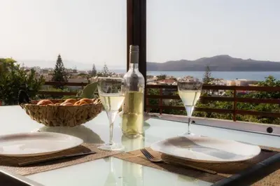 a table with glasses of wine and a basket of bread at Stalos View in Stalos