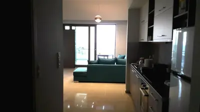 a living room with a green couch and a kitchen at Casa Bella Deluxe Apartments in Palaiochóra