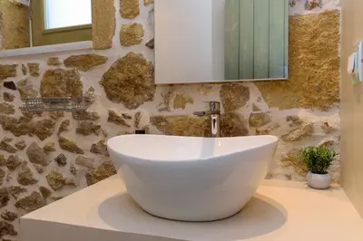 a bathroom with a white sink and a mirror at Effrosini Traditional Home in Nopíyia
