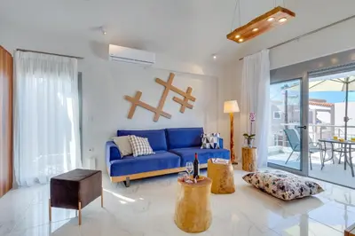 a living room with a blue couch and a table at Ikia Aretousa in Kato Daratso