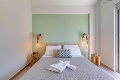 a bedroom with a large bed with towels on it at Ikia Aretousa in Kato Daratso