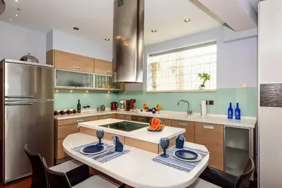 a kitchen with a table with chairs and a refrigerator at Blue Suite by Cosmos in Plataniás