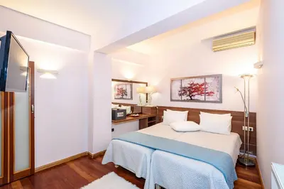 a hotel room with a bed and a tv at Blue Suite by Cosmos in Plataniás