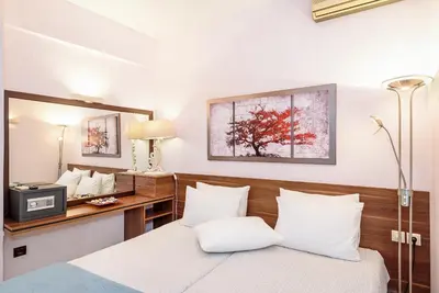 a bedroom with a bed with white pillows and a desk at Blue Suite by Cosmos in Plataniás