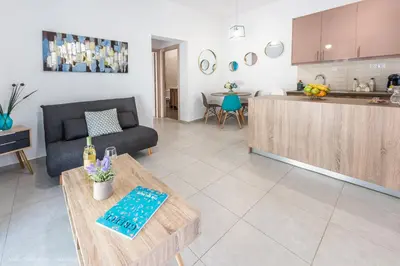 a kitchen and a living room with a couch and a table at Orama Suites I in Kato Daratso