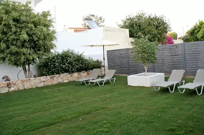 a group of chairs and an umbrella in a yard at Orama Suites I in Kato Daratso