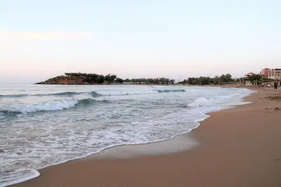 a beach with waves and people on the shore at Orama Suites I in Kato Daratso