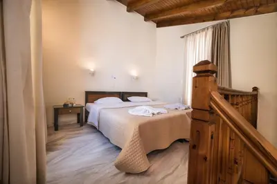 a bedroom with a large bed and a window at Mythos Beach Hotel Apartments in Maleme
