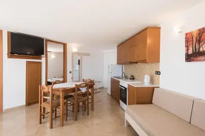 a kitchen and dining room with a table and chairs at Mythos Beach Hotel Apartments in Maleme